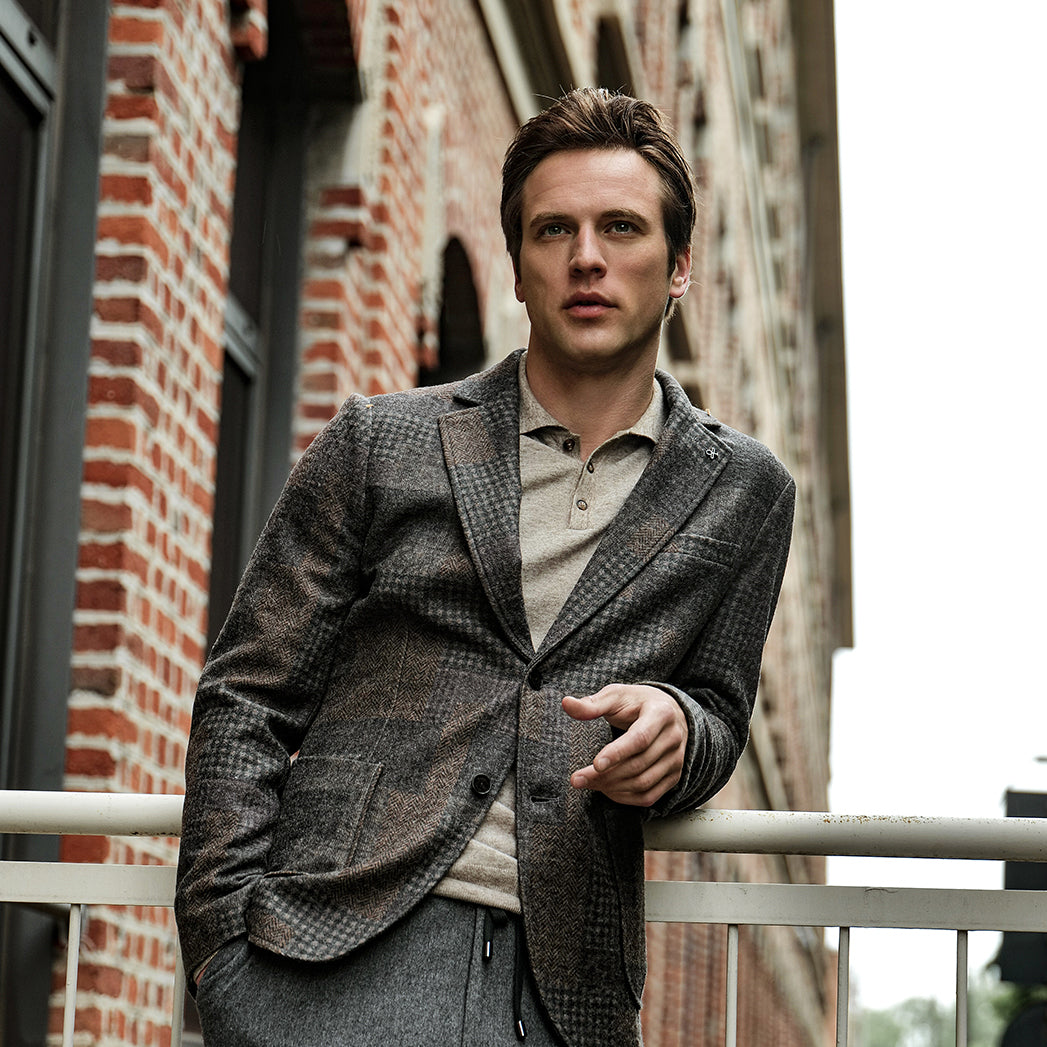A man wearing a blazer in an urban area