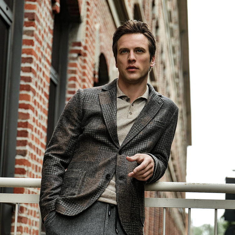 A man wearing a blazer in an urban area