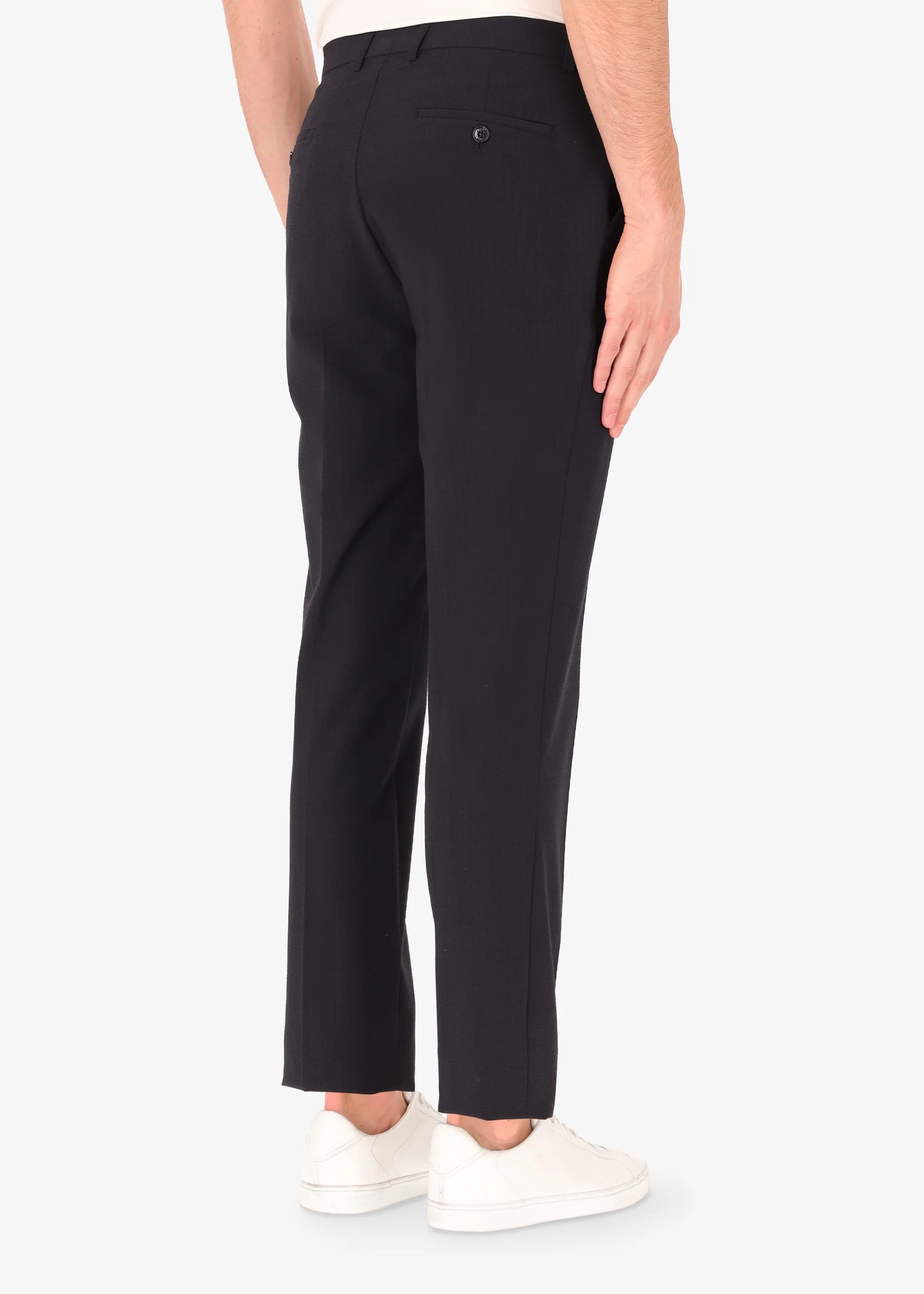 A back facing image of a model wearing Distretto 12 Tailoring Tech Trousers in blue.