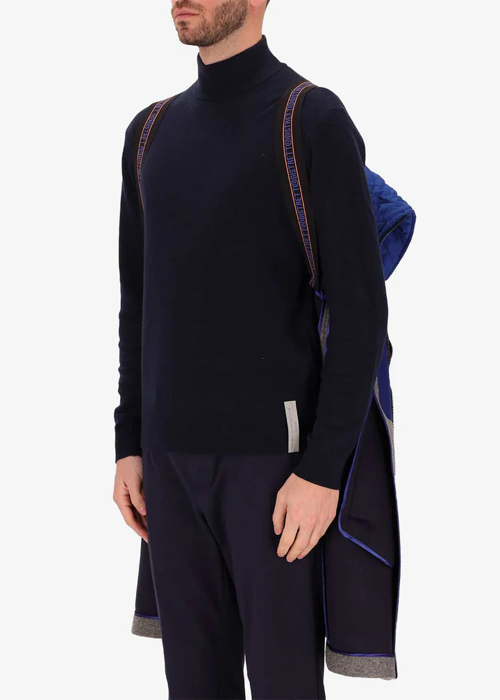 An image of a model wearing a Distretto12 coat Carlos in grey with light blue hood by the suspenders.