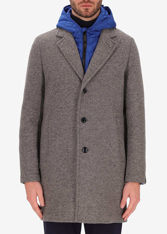 An image of a model wearing a Distretto12 coat Carlos in grey with light blue hood.
