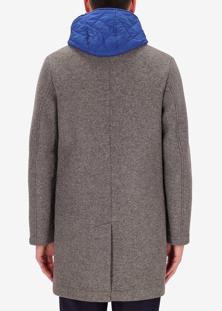 An image of a model wearing a Distretto12 coat Carlos in grey with light blue hood.
