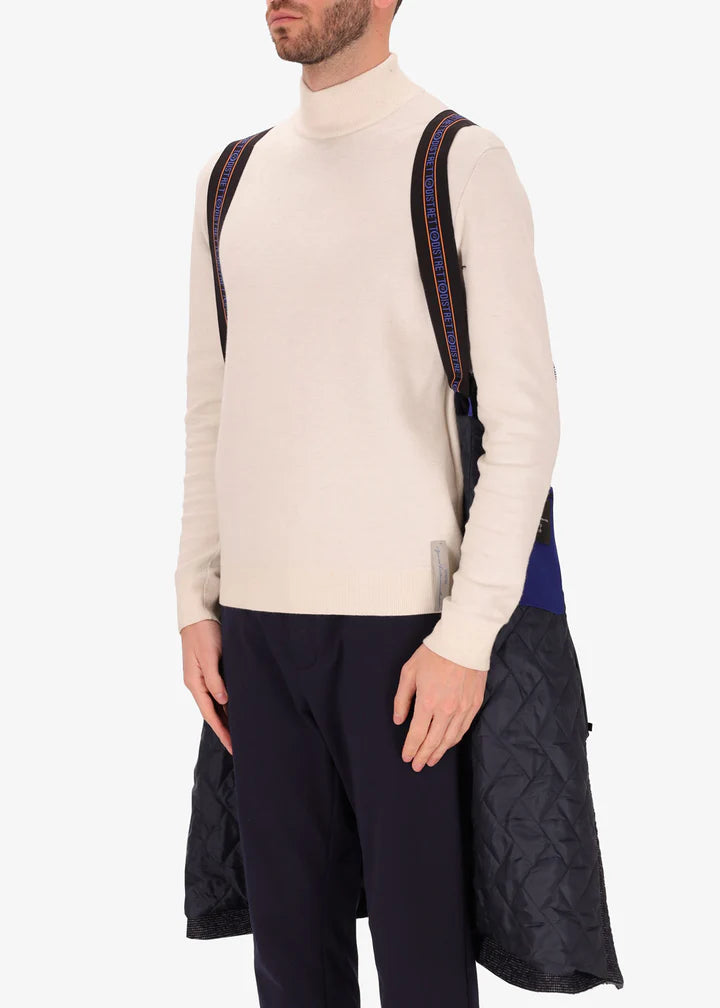 An imagee of a model wearing Distretto12 neck coat bicerin in grey with a blue chest insert, by the suspenders.