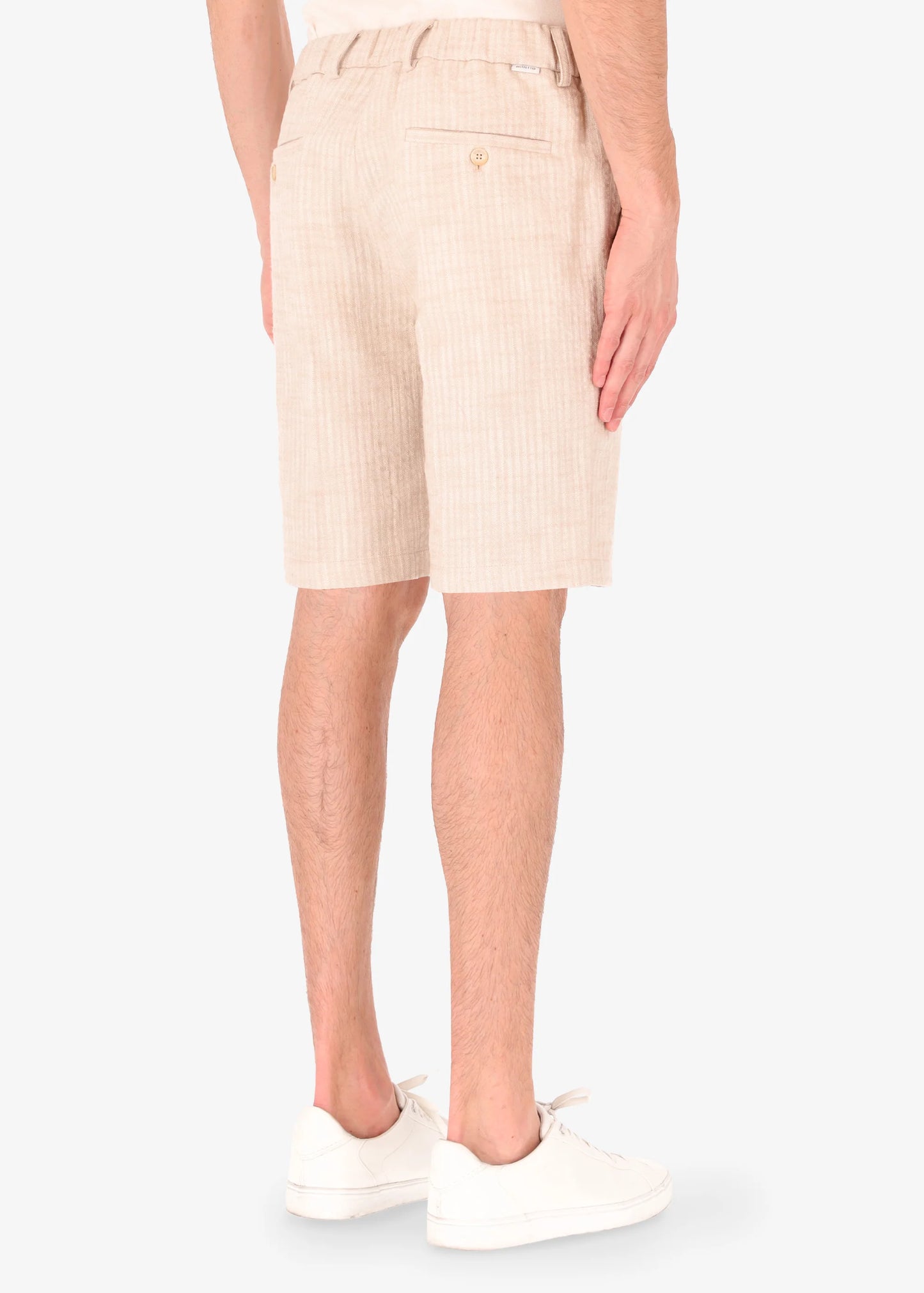 A back facing picture of a model wearing linen shorts from Distretto 12.