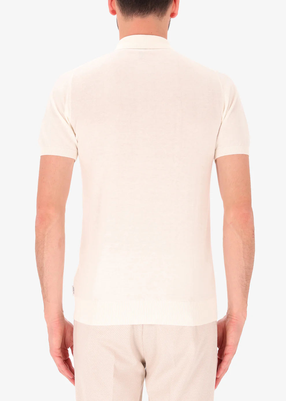 A back facing picture of a model wearing a knitted white polo from Distretto 12.