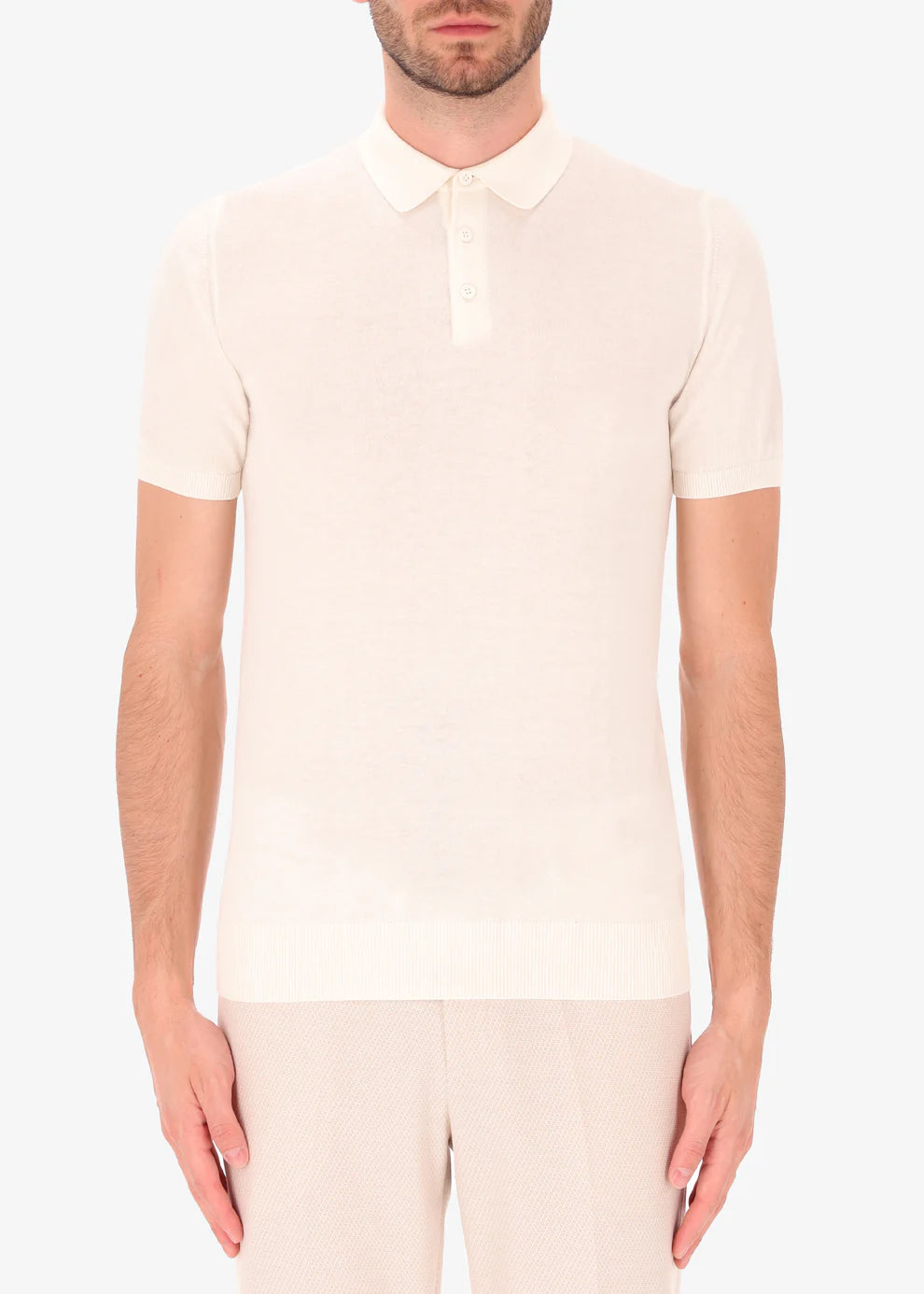 A front facing picture of a model wearing a knitted white polo from Distretto 12.