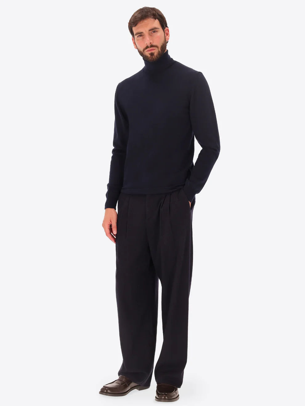 Male model wearing high neck knitwear by distretto12 in navy with wide leg trousers
