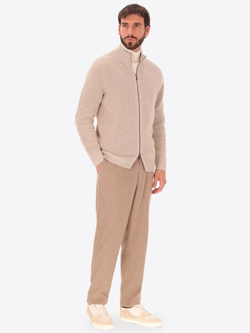 Male model wearing full zip, funnel neck knitwear by distretto12 in dove grey with wide legged trousers