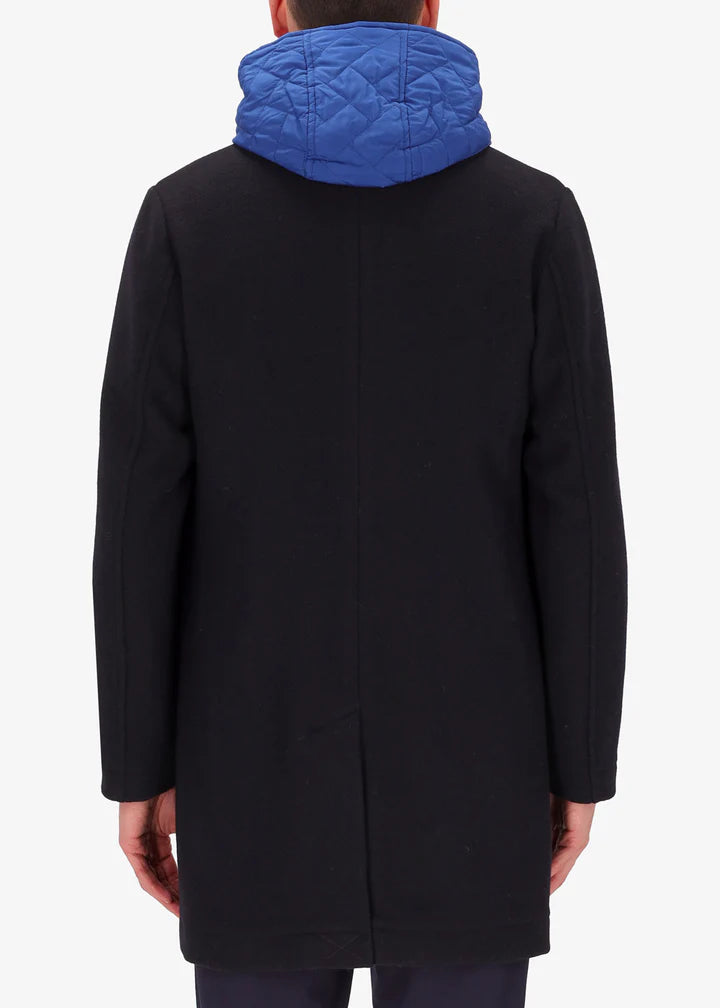 A back image of a model wearing a Distretto12 coat Smith in blue with light blue hood.