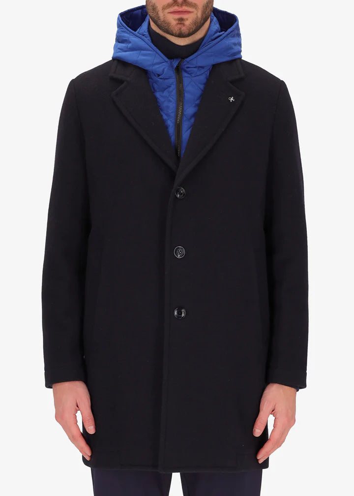 An image of a model wearing a Distretto12 coat Smith in blue with light blue hood.