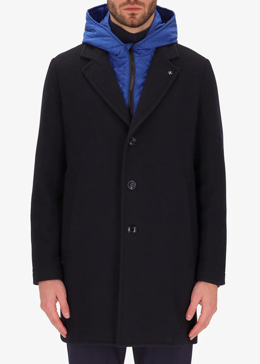 An image of a model wearing a Distretto12 coat Smith in blue with light blue hood.