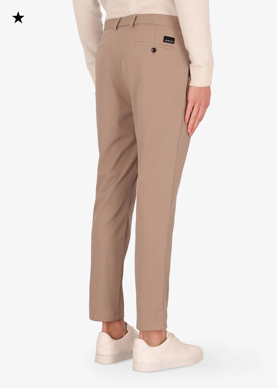 An image of a model wearing a Distretto12 H.P trousers in Sandalwood.