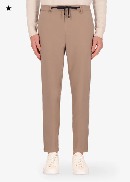 An image of a model wearing a Distretto12 H.P trousers in Sandalwood.