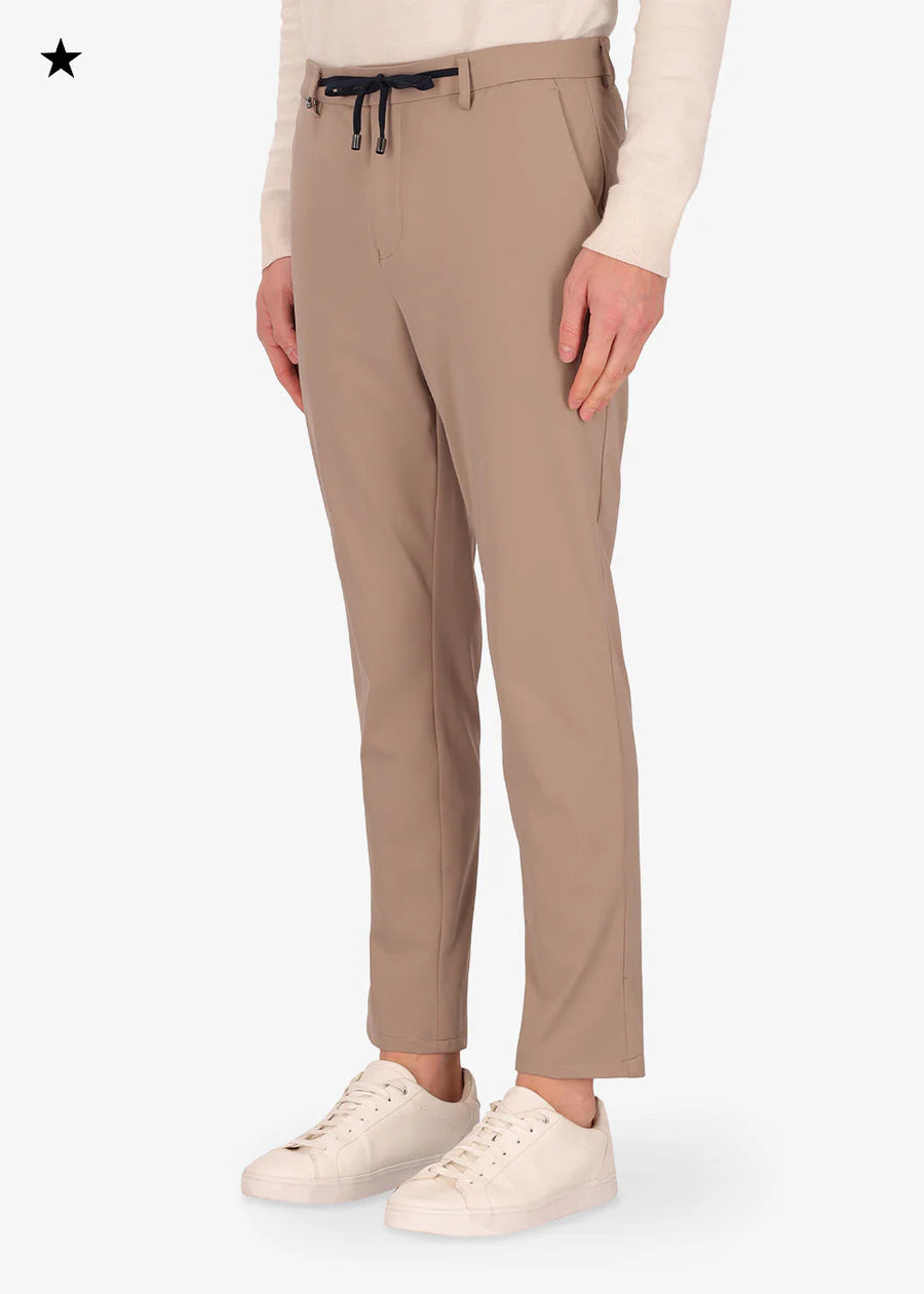An image of a model wearing a Distretto12 H.P trousers in Sandalwood.