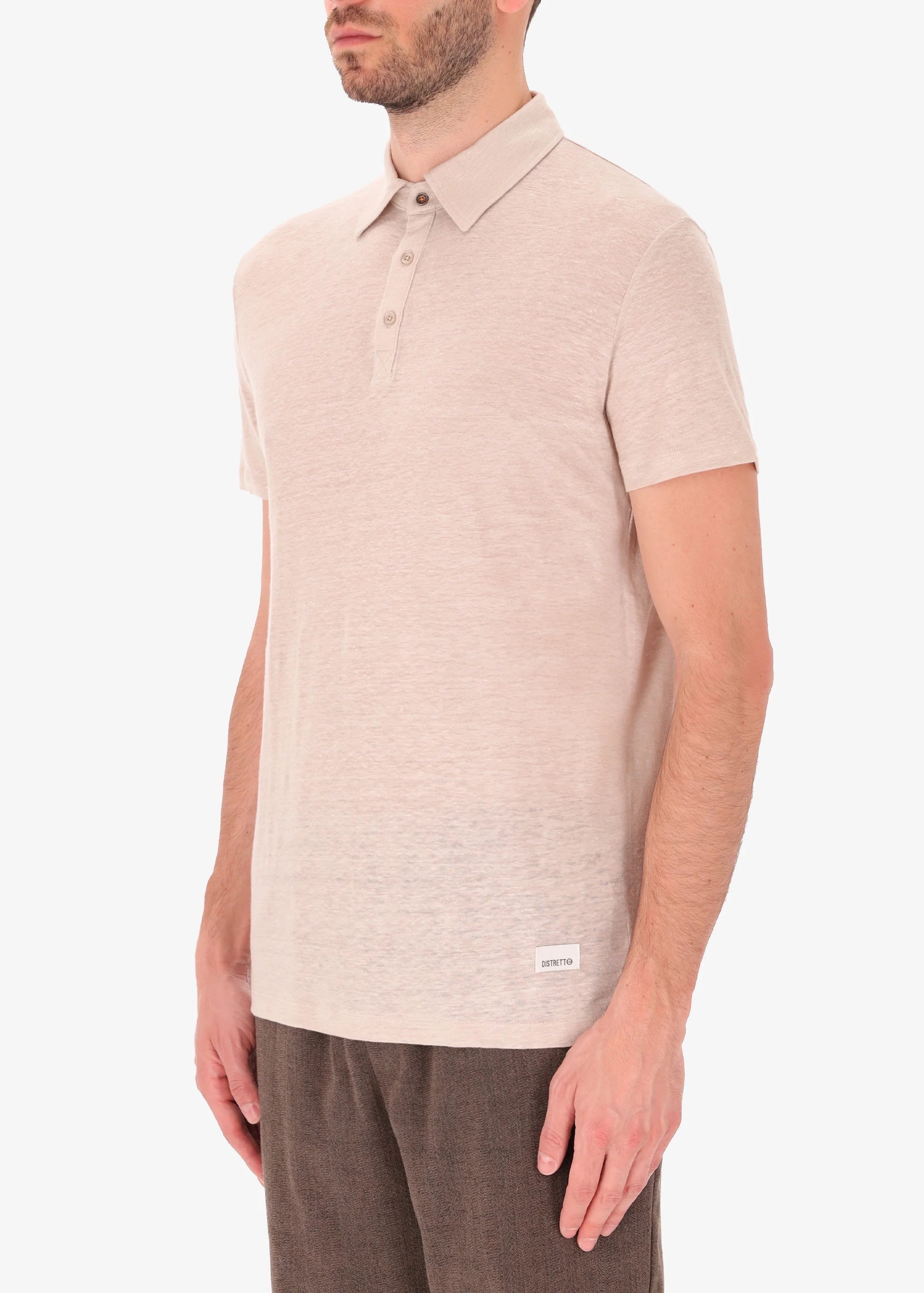 A side facing picture of a model wearing a linen rope coloured polo from Distretto 12.