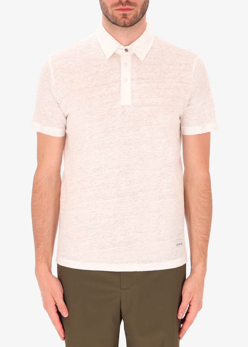 A model wearing a white linen polo from Distretto 12.