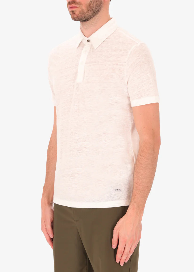 A side facing picture of a model wearing a white linen polo from Distretto 12.