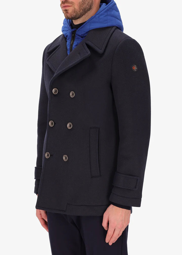 An image of a model wearing a Distretto12 peacoat cruise in blue with blue hood.