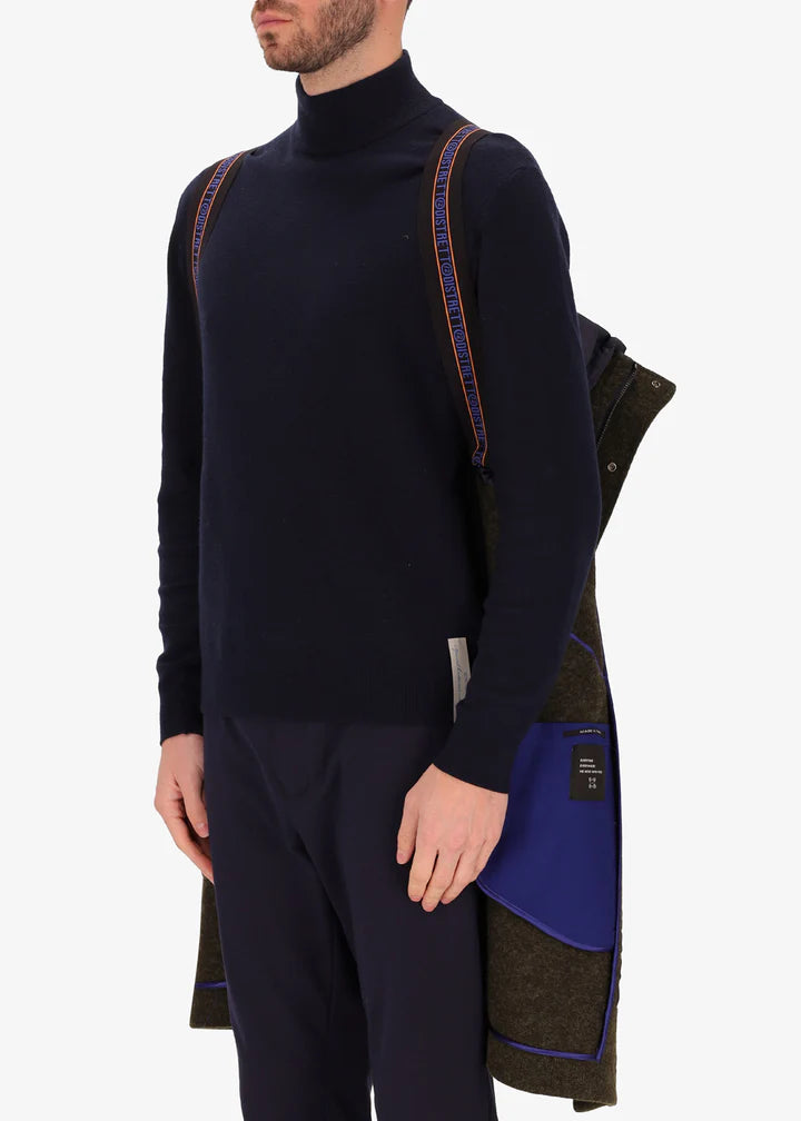 An image of a model wearing Distretto12 parka coat Valentino in Tobacco, with a blue hood by the suspenders.