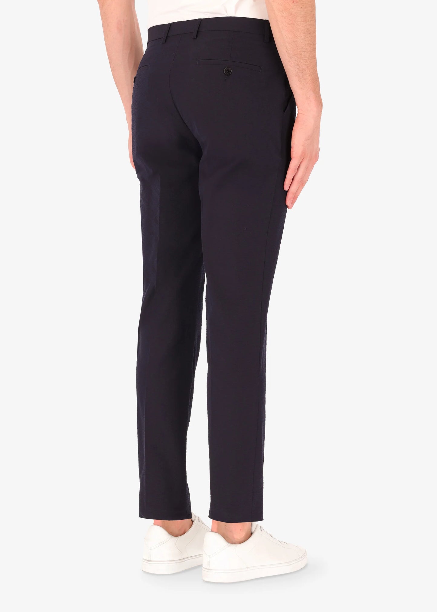 A back facing image of a model wearing Distretto 12 Tailoring tech Arezzo Trousers.