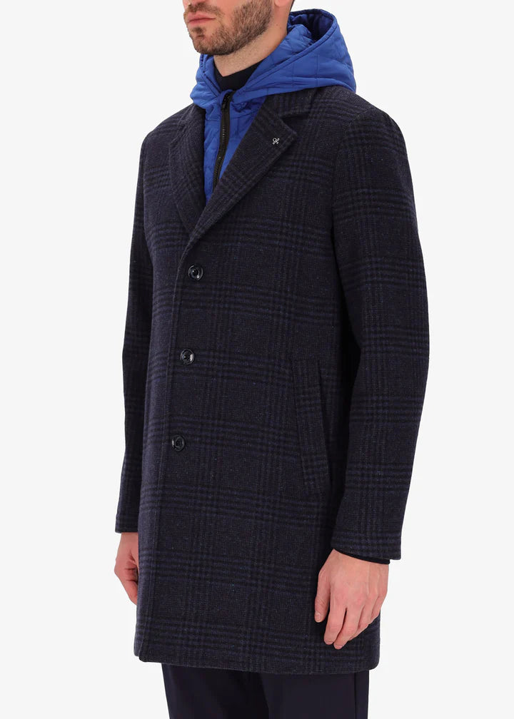 A side image of a model wearing a Distretto12 coat Scaglia in blue with light blue hood.
