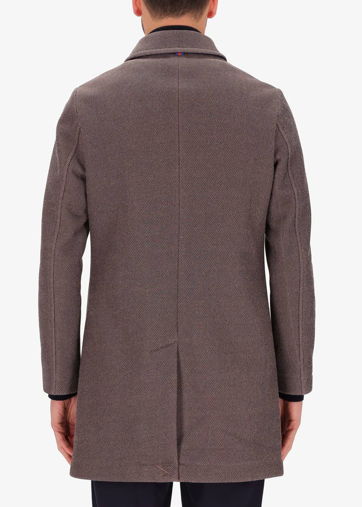 A back facing image of a model wearing a Distretto 12, trench coat in brown.
