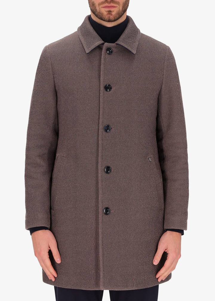 A front facing image of a model wearing a Distretto 12, trench coat in brown.