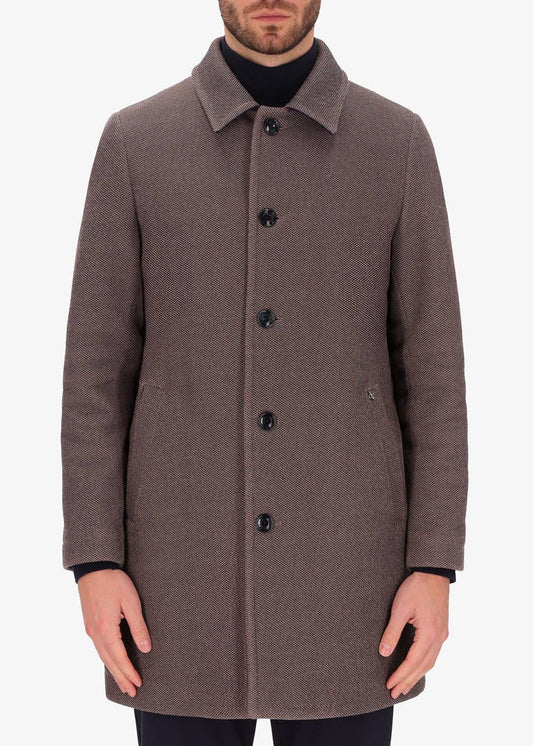 A front facing image of a model wearing a Distretto 12, trench coat in brown.