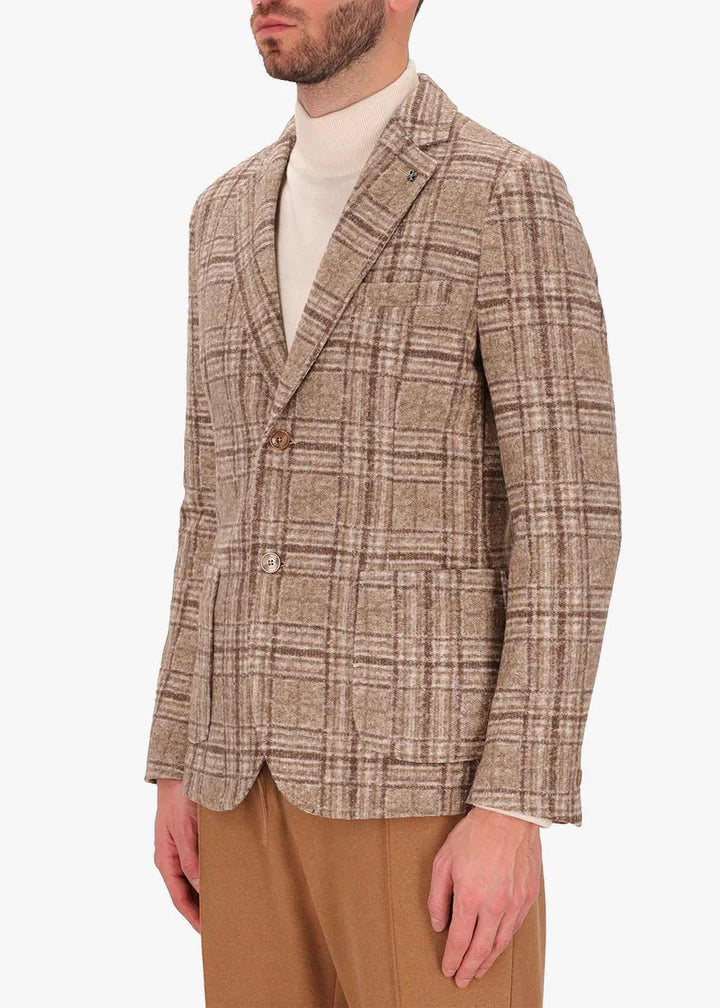 An image of a model wearing a Distretto12 Jacket Osea in camel.