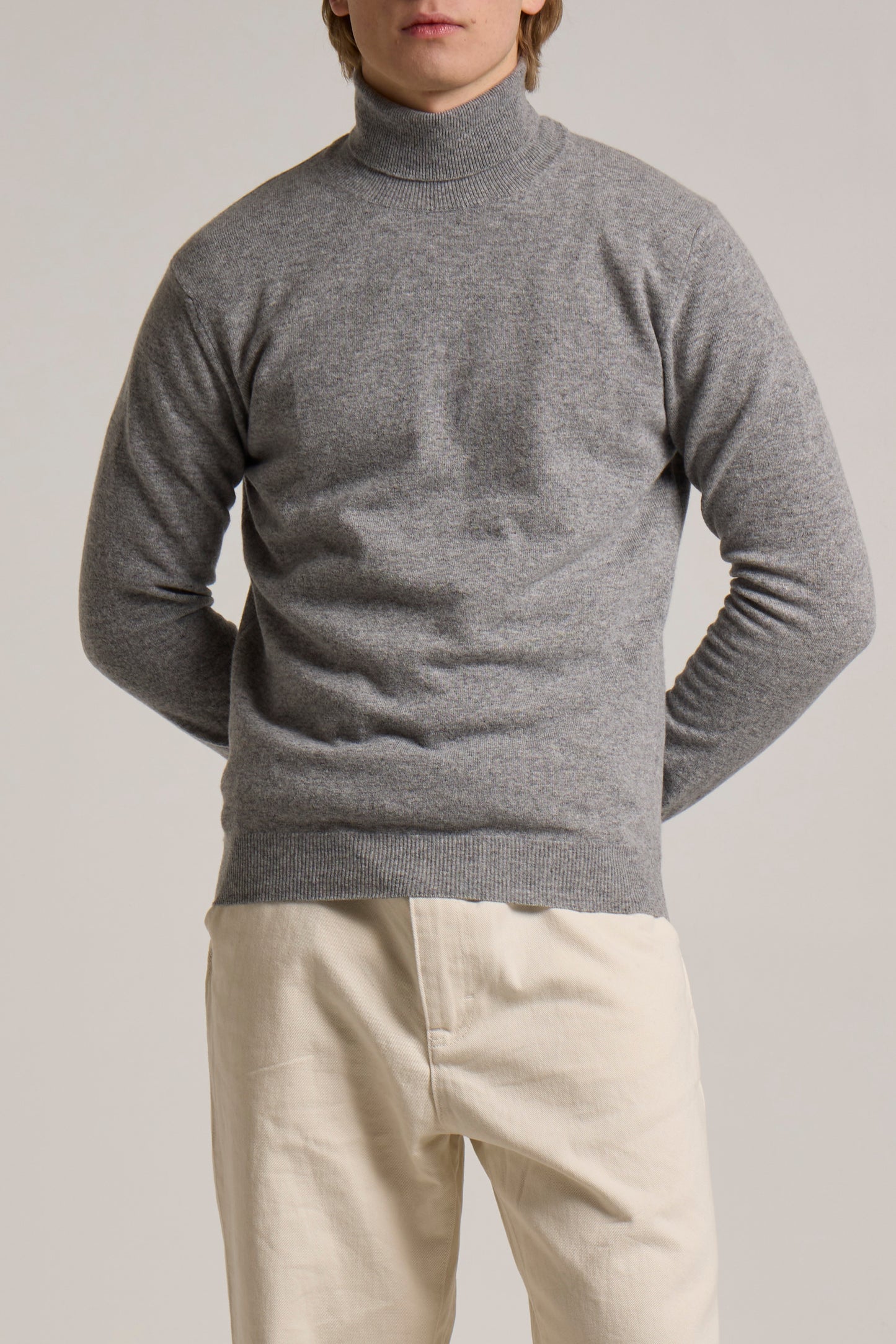 A model wearing a grey Wool&Co rollneck knitwear.