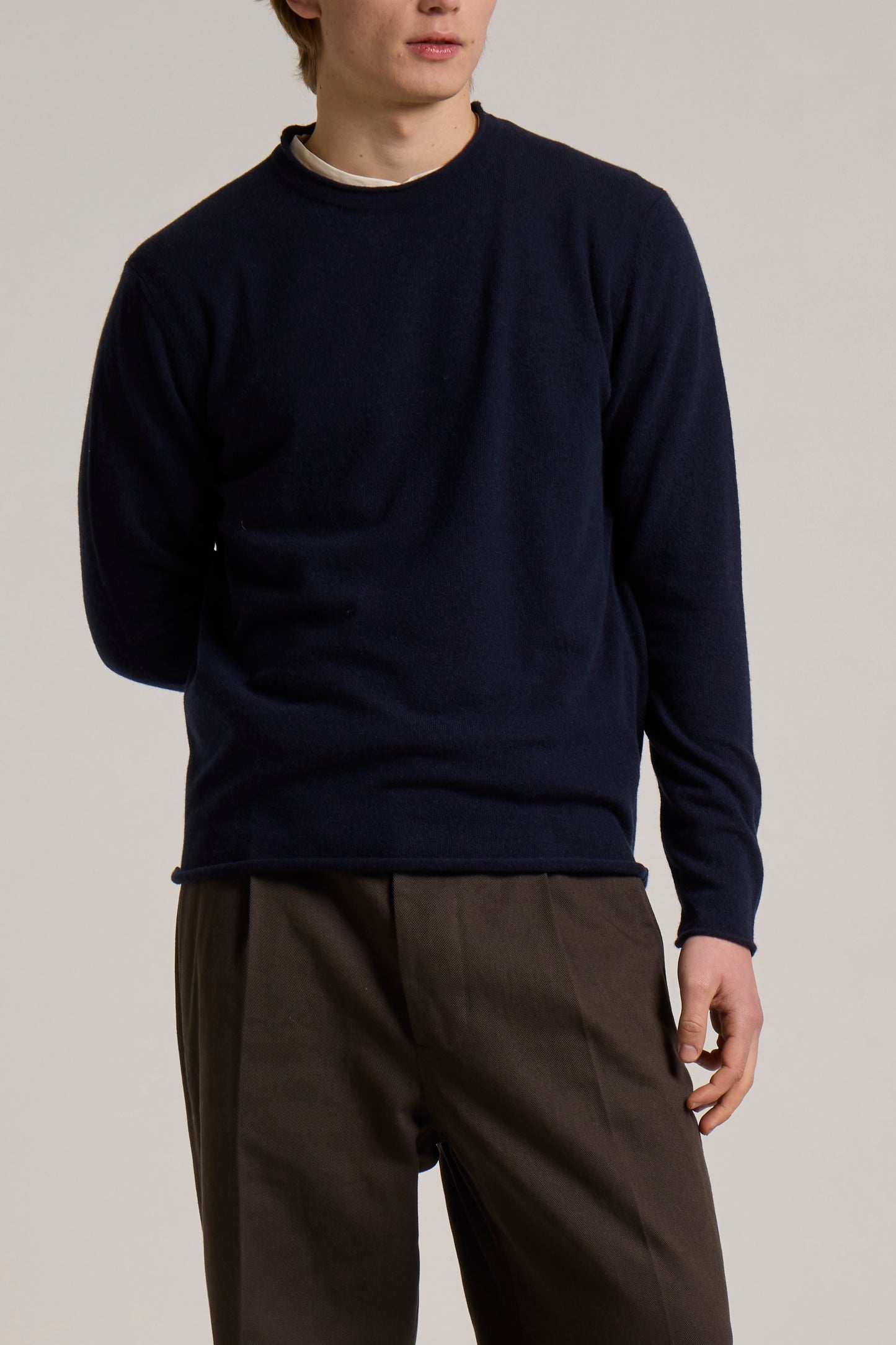 A model wearing a navy Wool&Co crewneck knitwear.