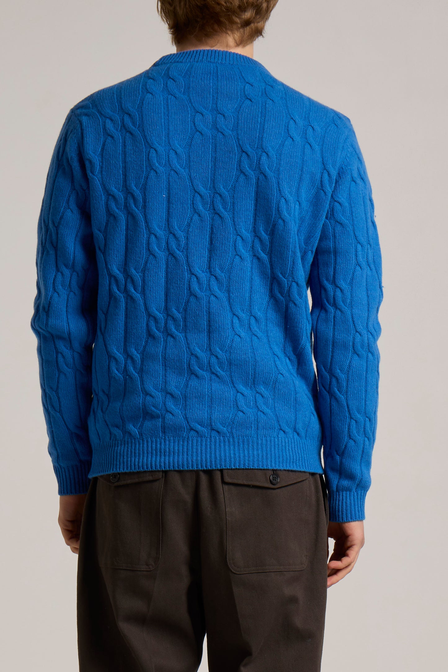 A model wearing a sky blue Wool&Co crewneck knitwear with cableknit design.