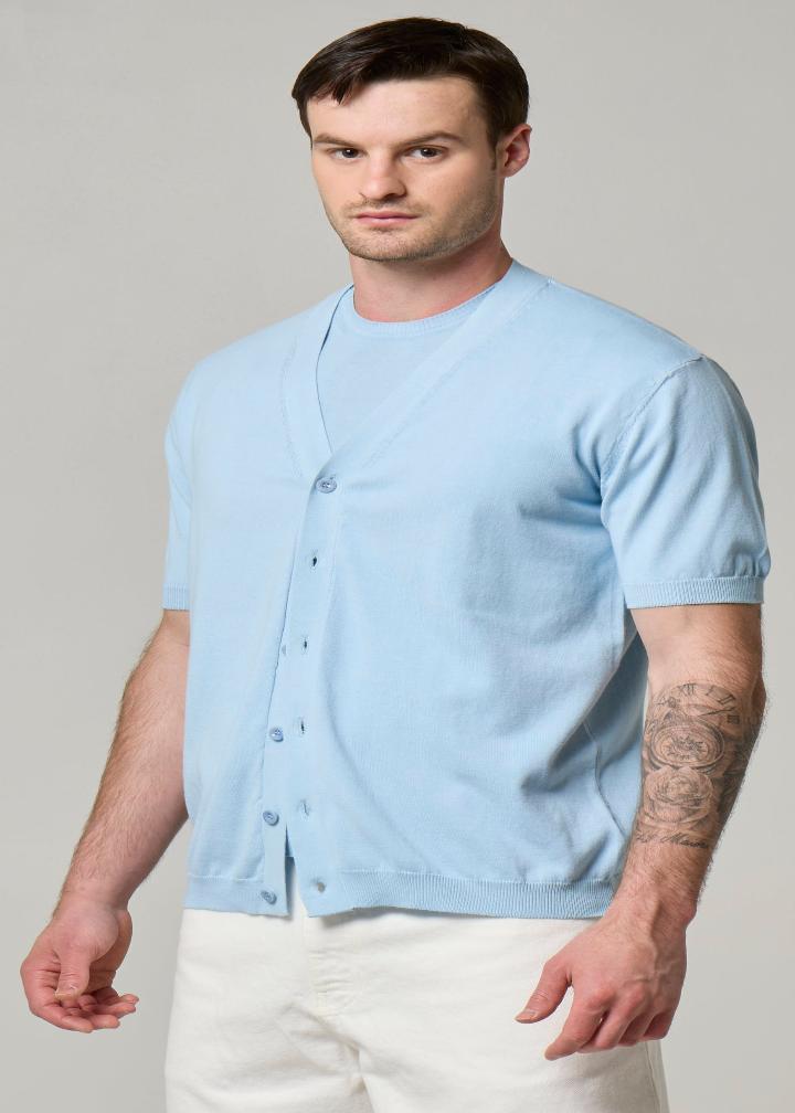 A picture of a model wearing a short sleeve Wool&Co cardigan in sky blue.