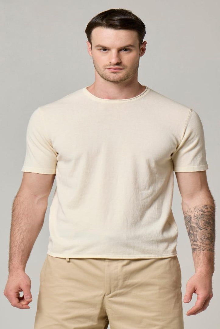 A picture of a model wearing a crewneck, Wool&Co T-shirt in cream.