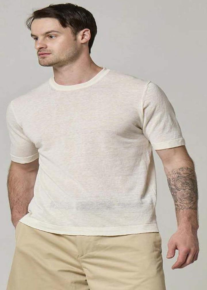 A picture of a model wearing a short sleeve, linen T-shirt in cream.
