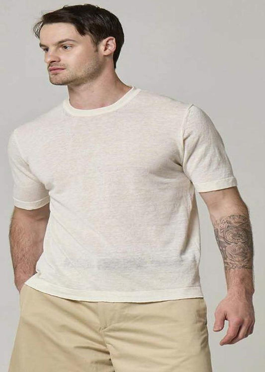 A picture of a model wearing a short sleeve, linen T-shirt in cream.