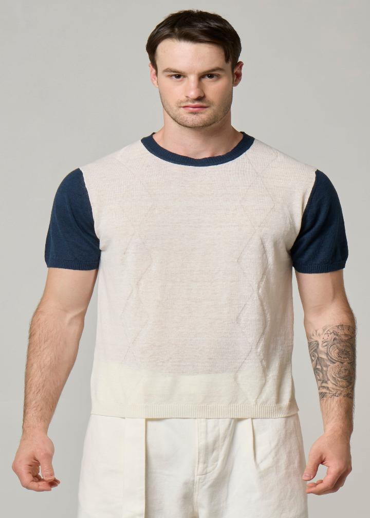An image of a model wearing a linen t shirt in cream with navy sleeves.