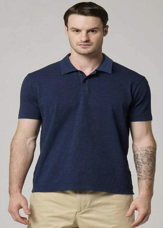 A picture of a model wearing a navy polo made from cotton.