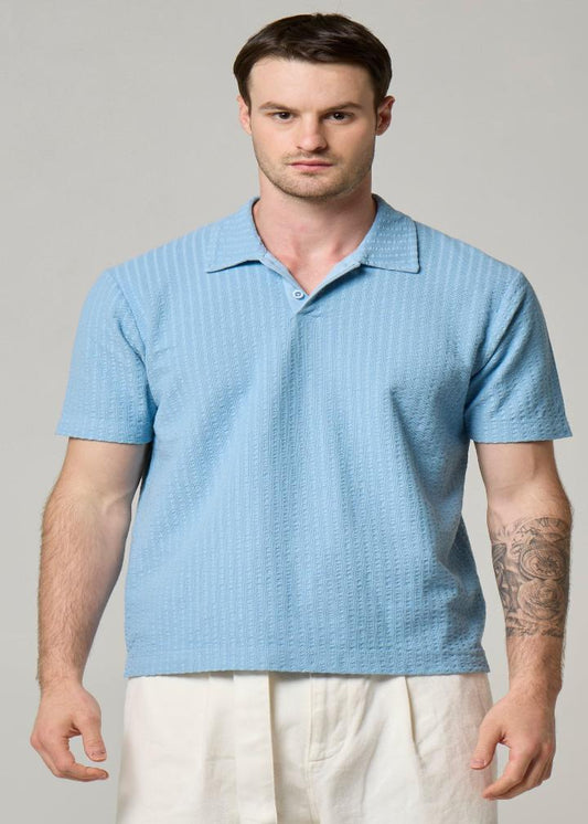A picture of Wool&Co sky blue polo with seersucker finish.