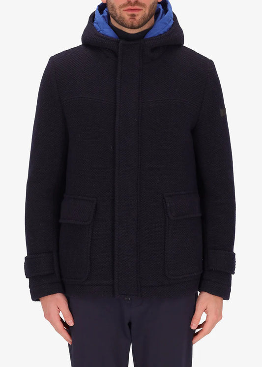 An image of a model wearing a Distretto12 hooded coat Blasius in blue with light blue hood.