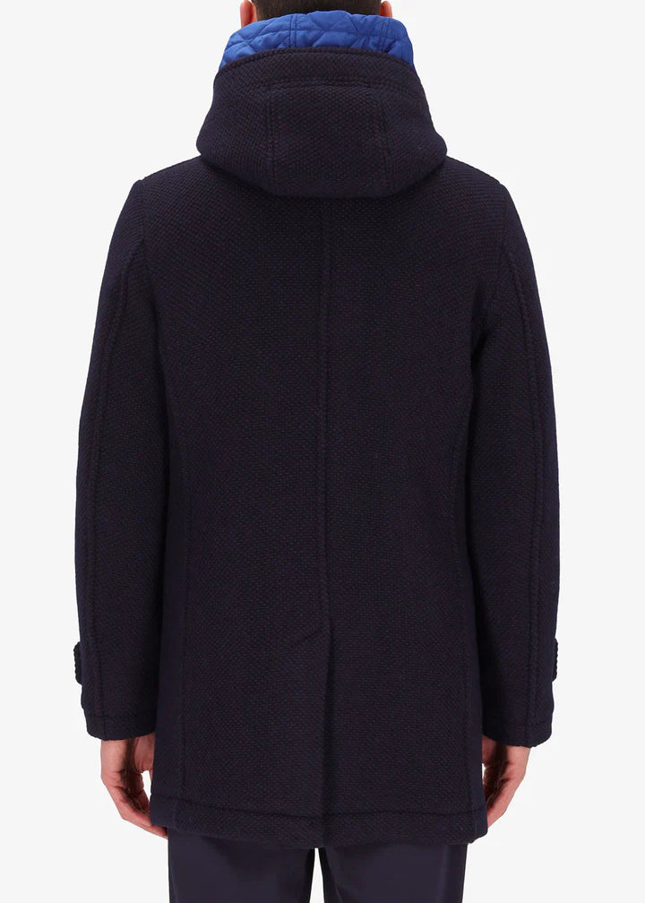 A back image of a model wearing a Distretto12 parka in blue with light blue hood.