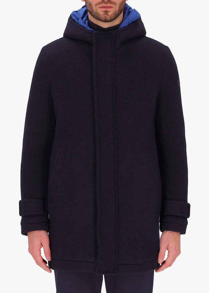 An image of a model wearing a Distretto12 parka in blue with light blue hood.