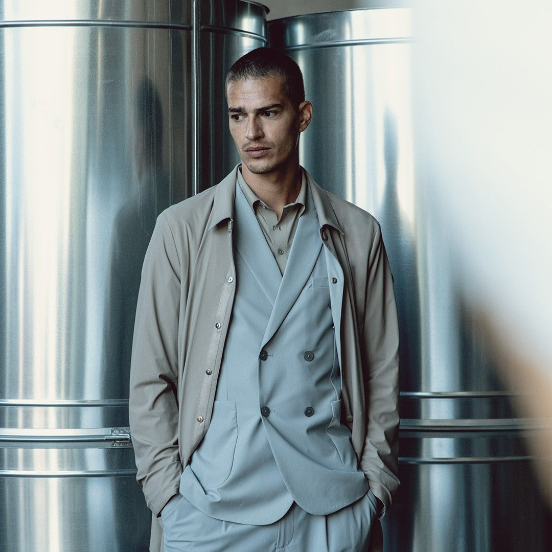 A man in an industrial setting wearing Distretto12 active trench coat.
