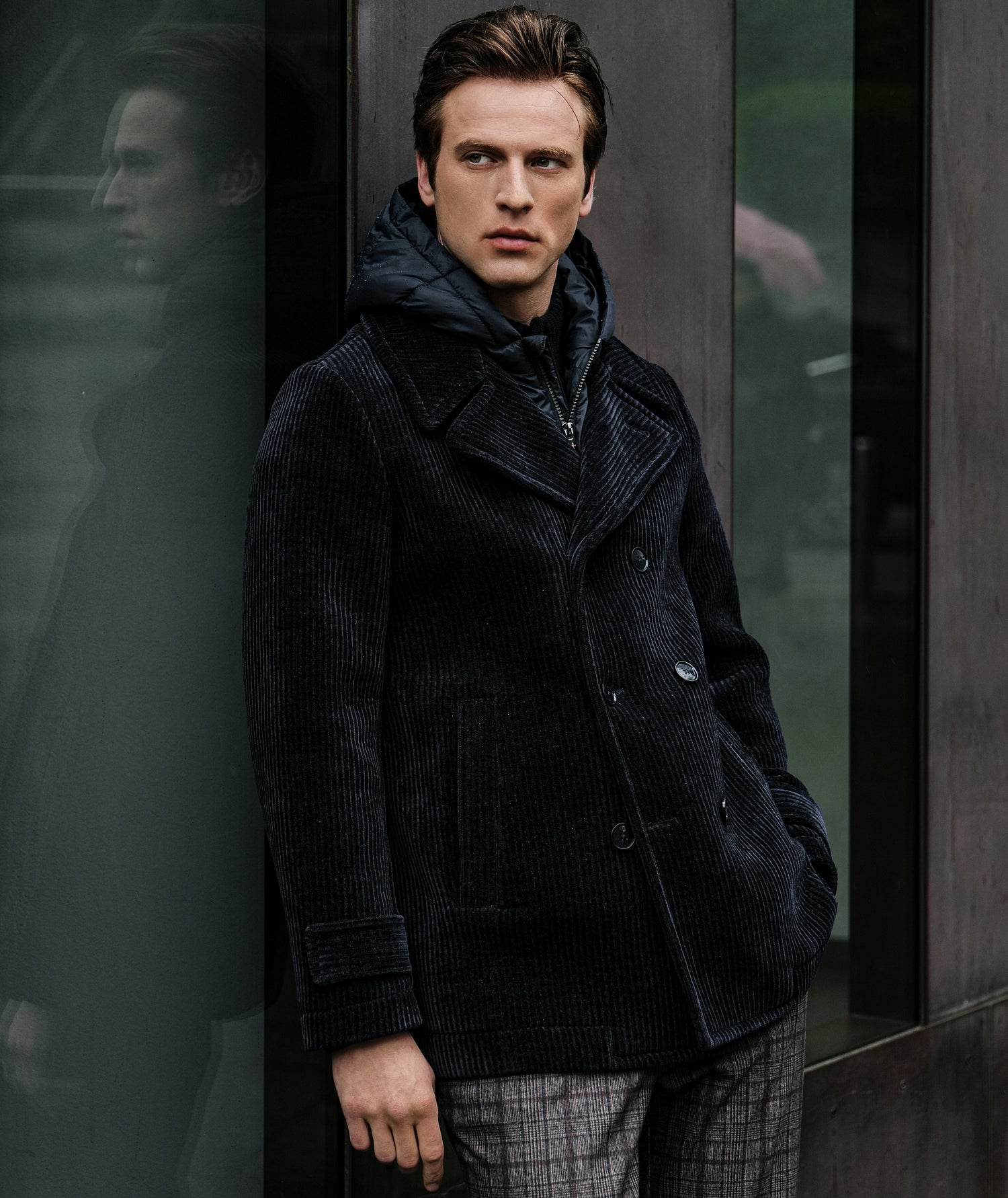 A man wearing a hooded cream overcoat with corduroy velvet detail