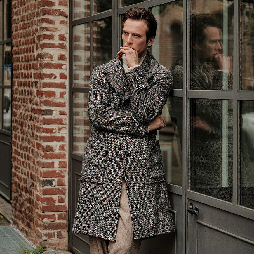 A man wearing a long wool overcoat in grey