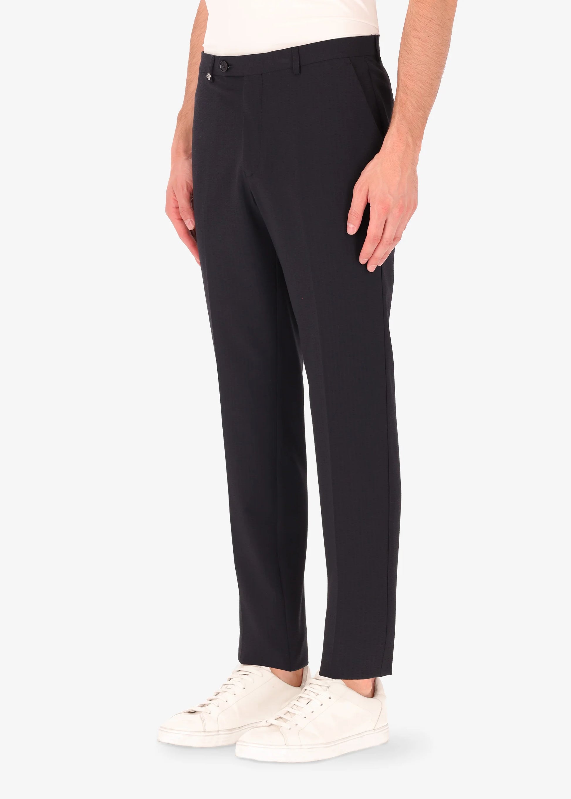 A side facing image of a model wearing Distretto 12 Tailoring Tech Trousers in blue.