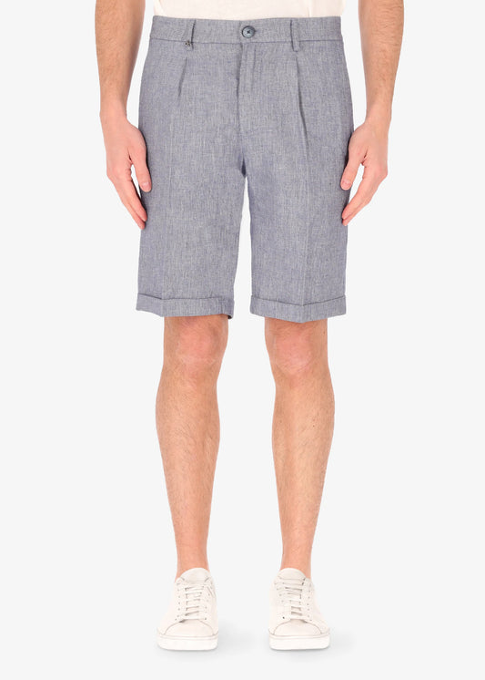 A picture of a model wearing linen blend shorts from Distretto 12 in blue.