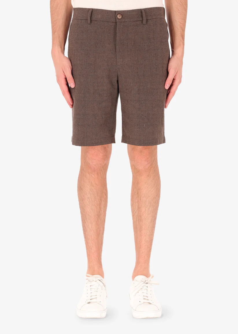A front facing image of a model wearing linen shorts from Distretto 12.