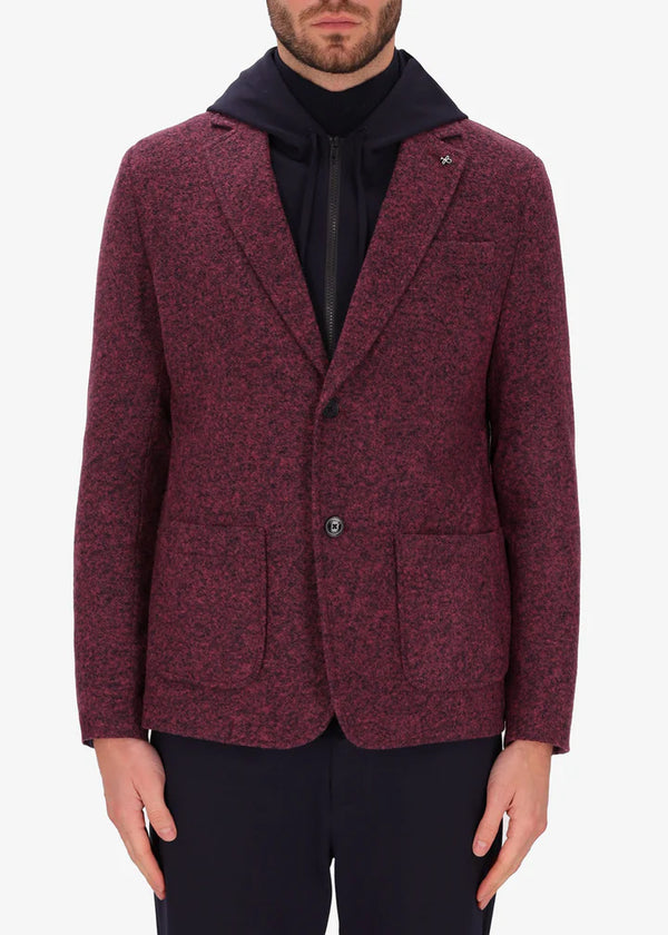 An image of a model wearing a Distretto12 jacket Isaia in mahogany with blue hood.