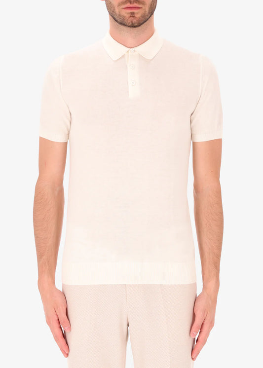 A front facing picture of a model wearing a knitted white polo from Distretto 12.